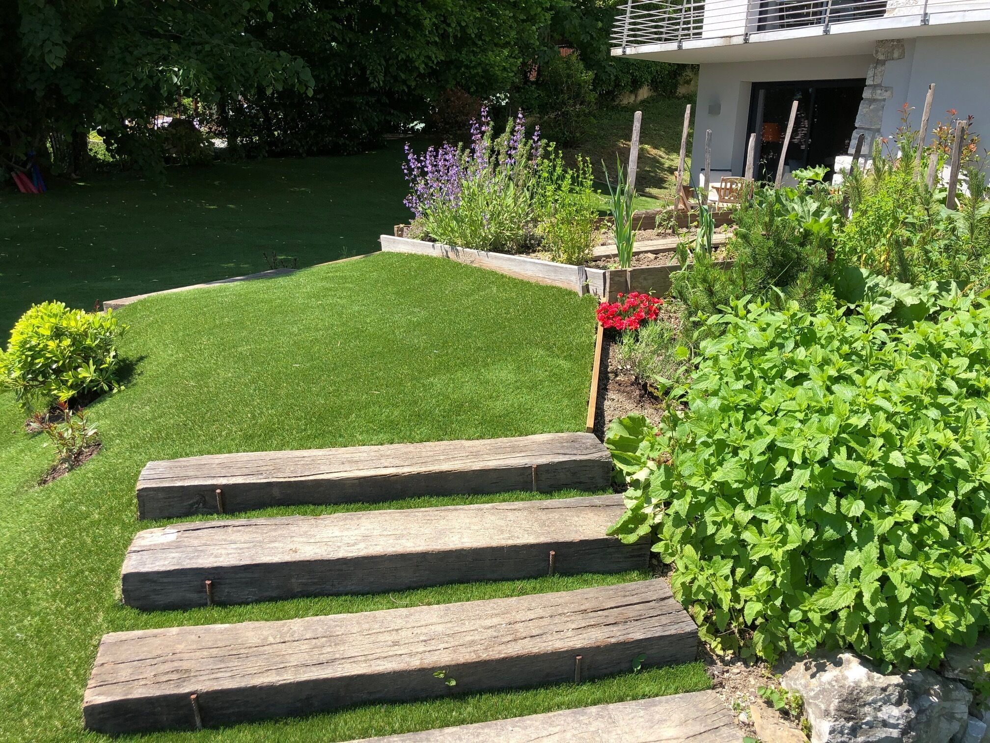 Un jardín bien cuidado con una escalera de madera que sube hacia una casa.