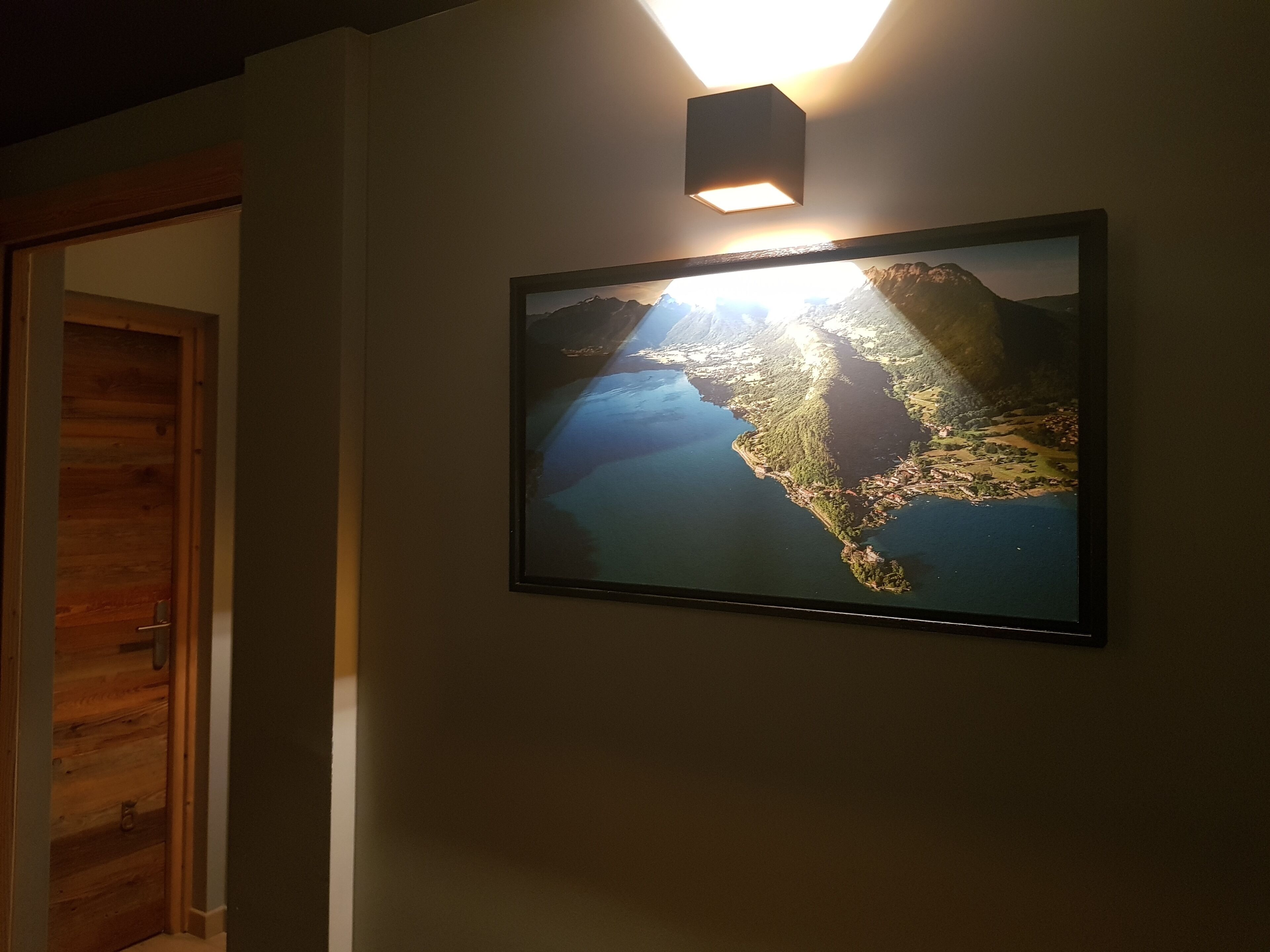 A framed map on a wall with a light above it.