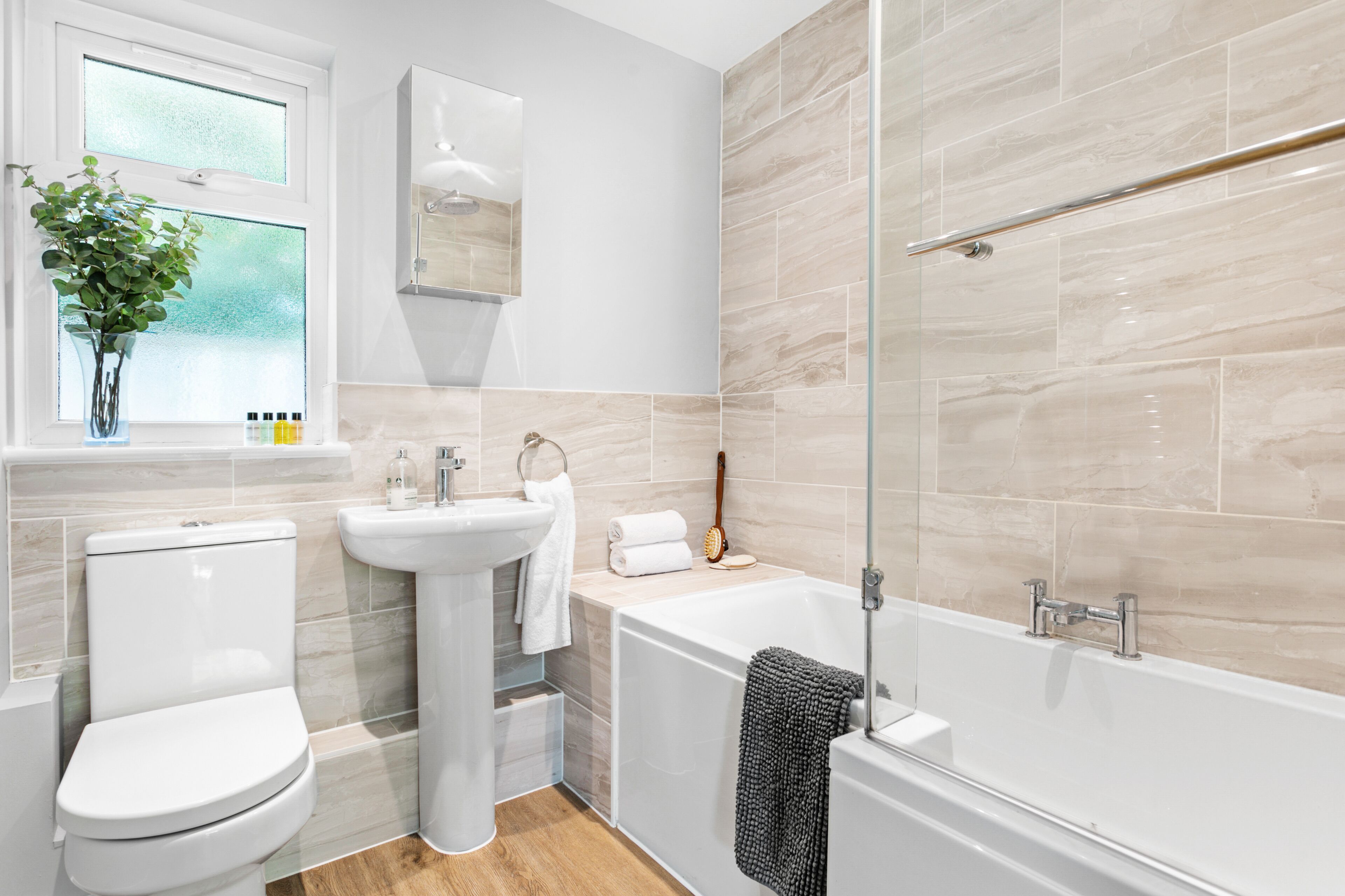 A modern bathroom with a toilet, sink, and bathtub.
