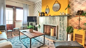 A living room with a fireplace, a sofa, a coffee table, and a TV.