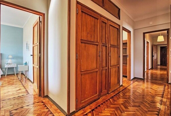 Stylish hallway with a herringbone-patterned floor leading to a spacious wardrobe.