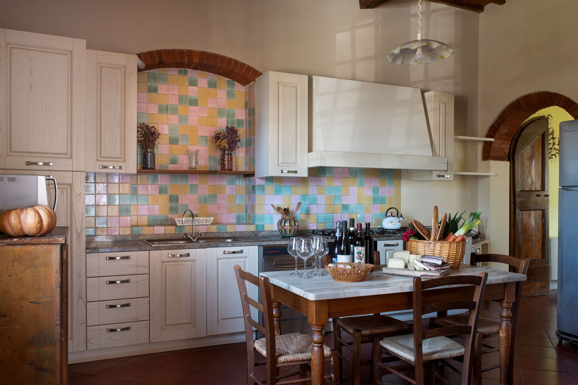 A kitchen with white cabinets, a tiled backsplash, and a dining table with chairs.