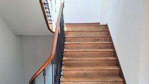 Eine Holztreppe mit geschwungener Handlauf und schwarzen Spindeln.