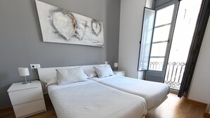 Une chambre avec un grand lit double, une grande fenêtre et une vue sur l’extérieur.