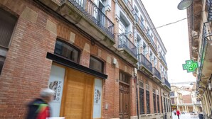 Une vue de rue avec un bâtiment doté d’une porte en bois et d’une enseigne sur laquelle on peut lire « FAUNO PARTIMIENTOS ».