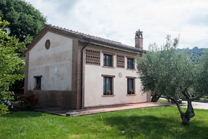 A two-story house with a tiled roof, a brick chimney, and a small balcony. - Casale Giorgio (Magione)