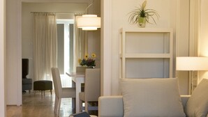 Un salon moderne avec un canapé d’angle, une table basse et un coin repas à l’arrière-plan.