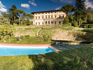 Un edificio grande con piscina y cancha de tenis.
