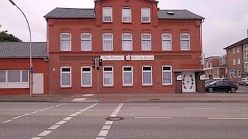 Ein rotes Backsteinhaus mit einem Schild für 'Hotel-Restaurant Gruner Kranz' an einer Straßeneinmündung.