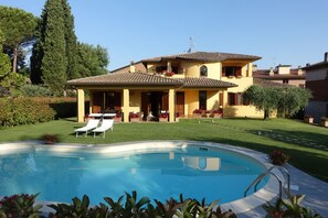 A two-story house with a swimming pool, a well-maintained lawn, and a clear sky. - Villa Pali (Marsciano)