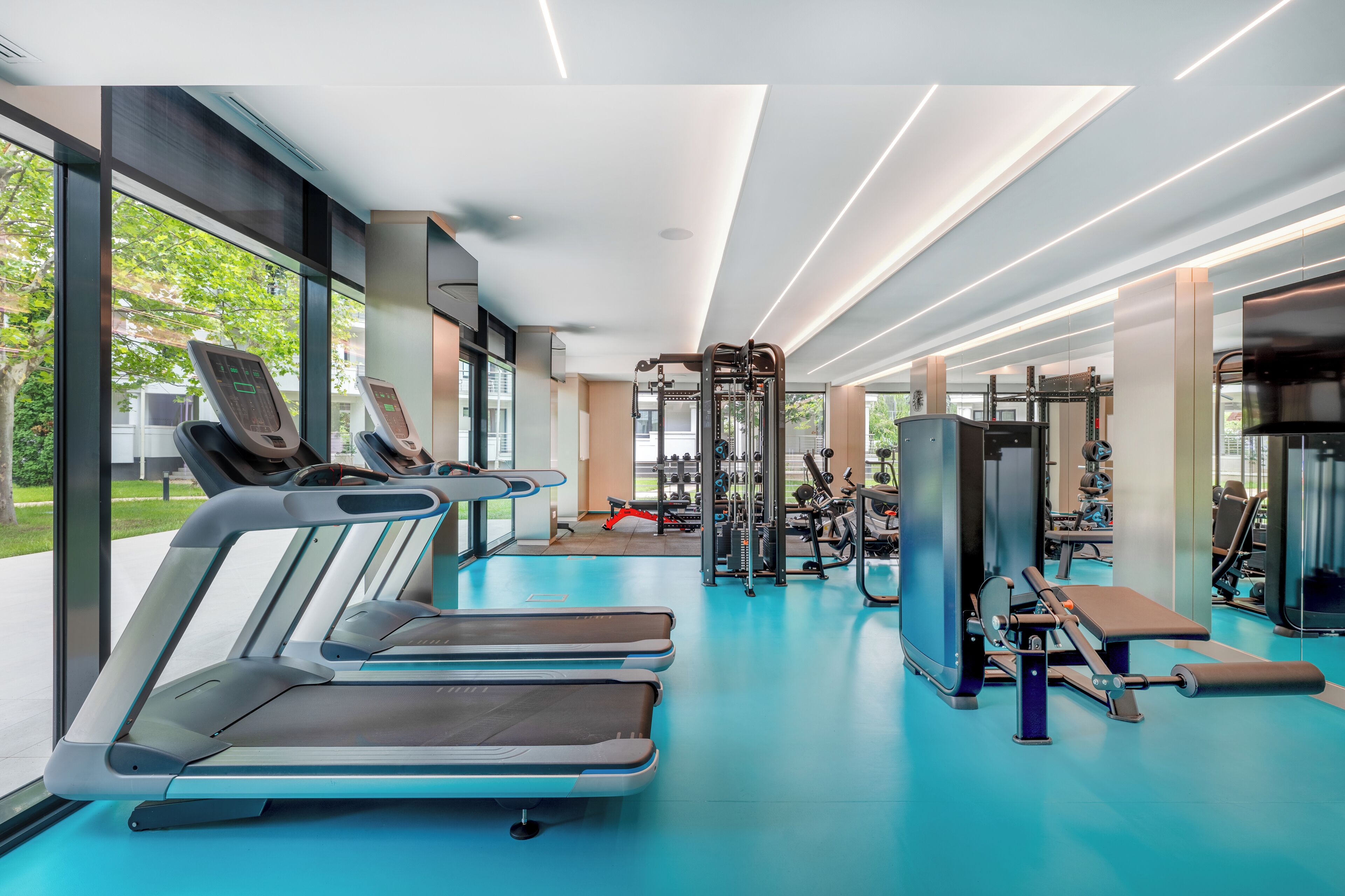 A modern gym with treadmills, weight machines, and exercise equipment.