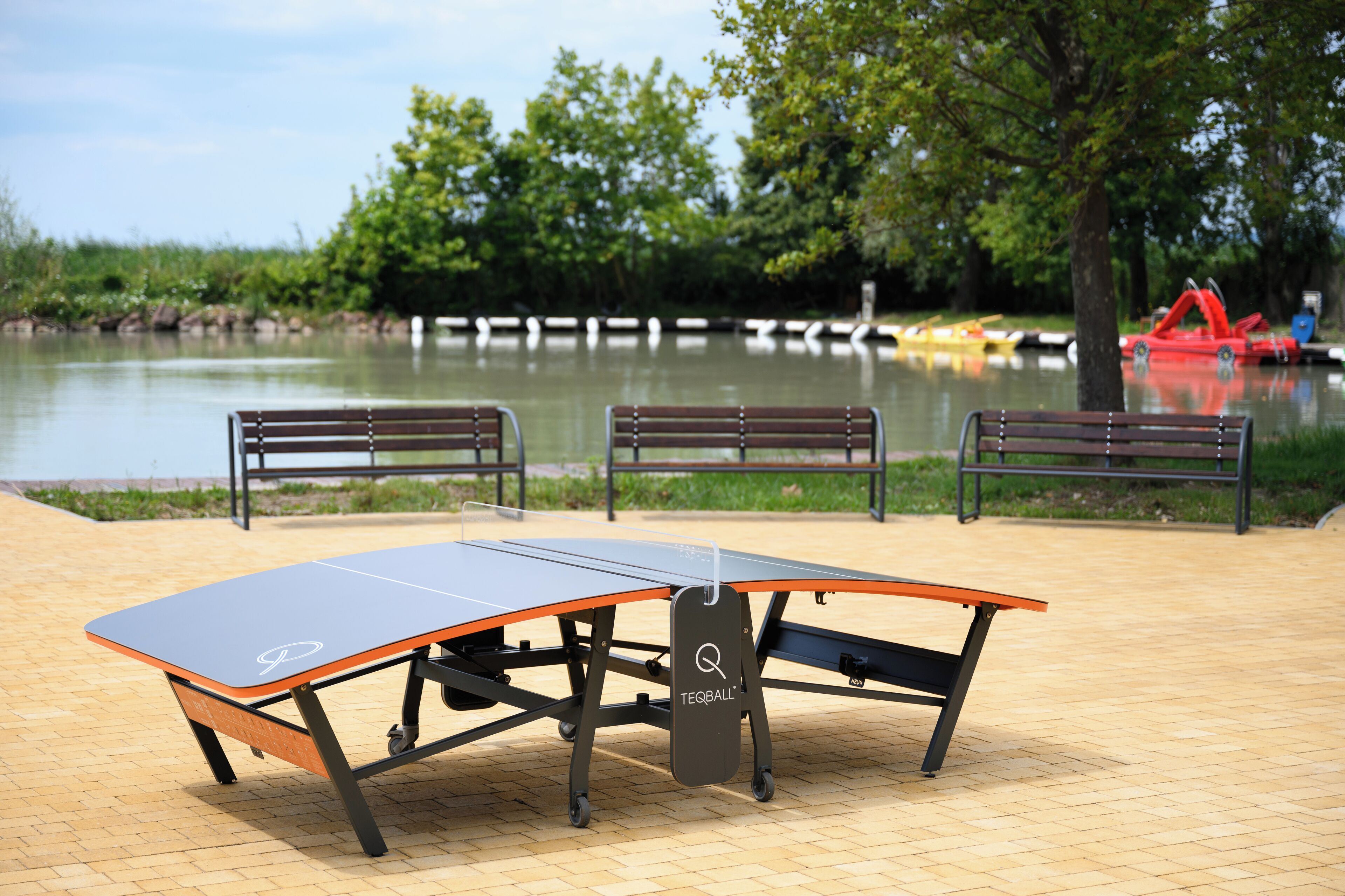 A ping pong table with benches in a park setting.
