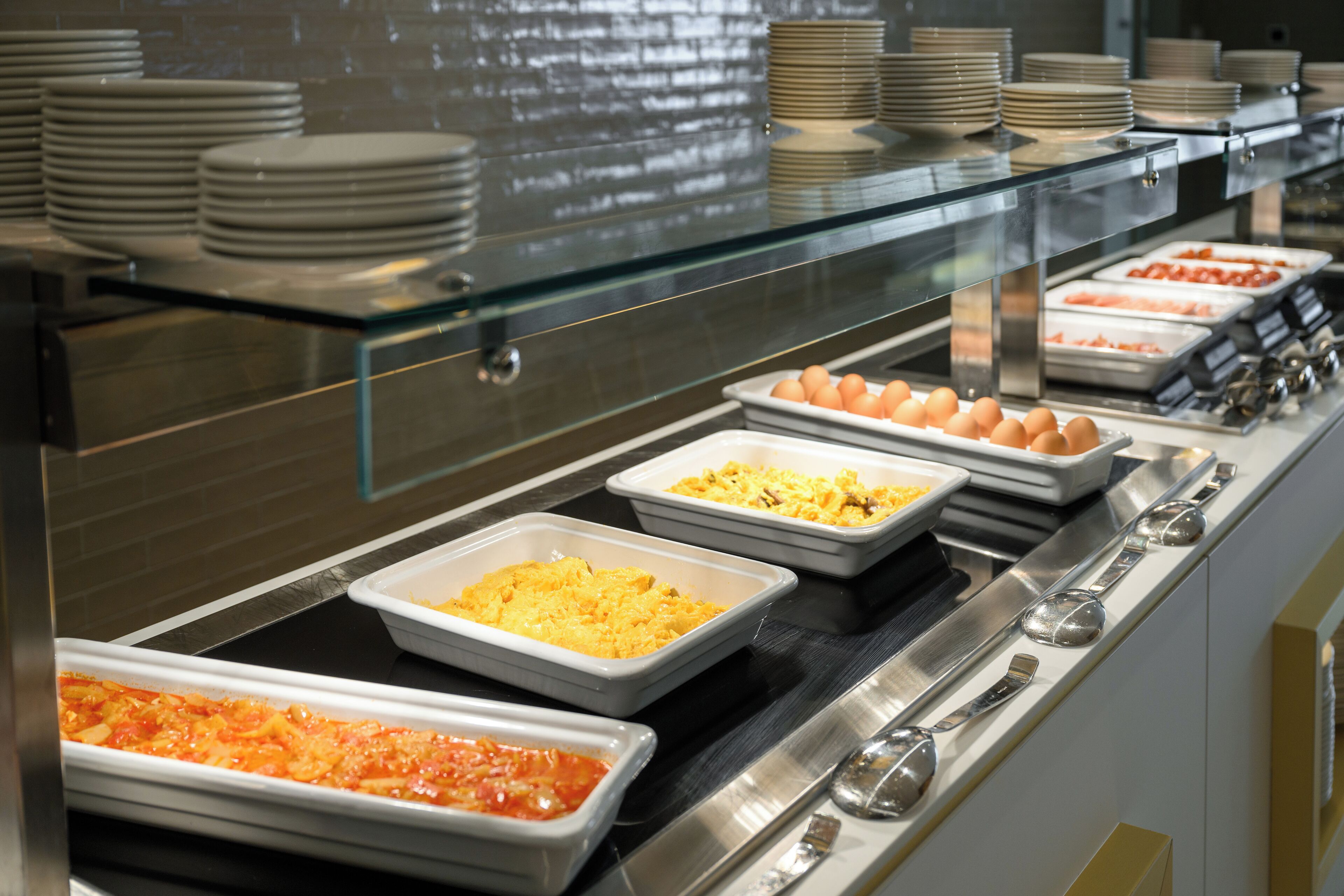 Un bufé con diversos alimentos y utensilios.