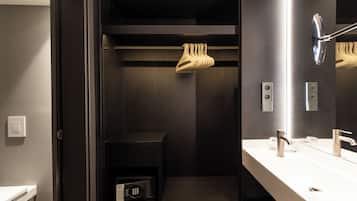 A modern bathroom with a built-in shower, a vanity with a mirror, and a towel rack.