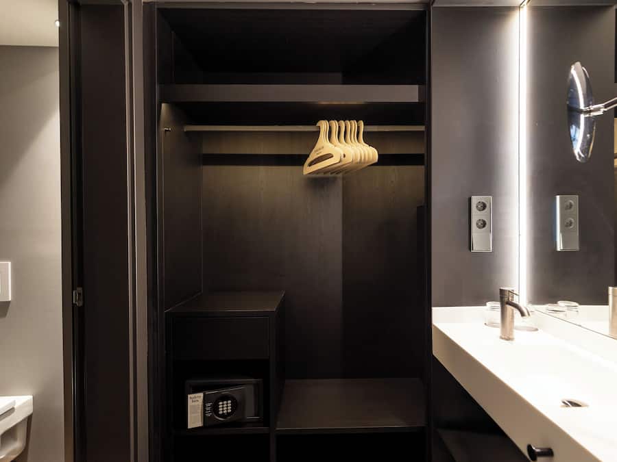 A modern bathroom with a built-in shower, a vanity with a mirror, and a towel rack.