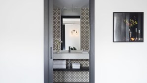 Une salle de bain avec un miroir, un porte-serviettes et un tableau encadré au mur.