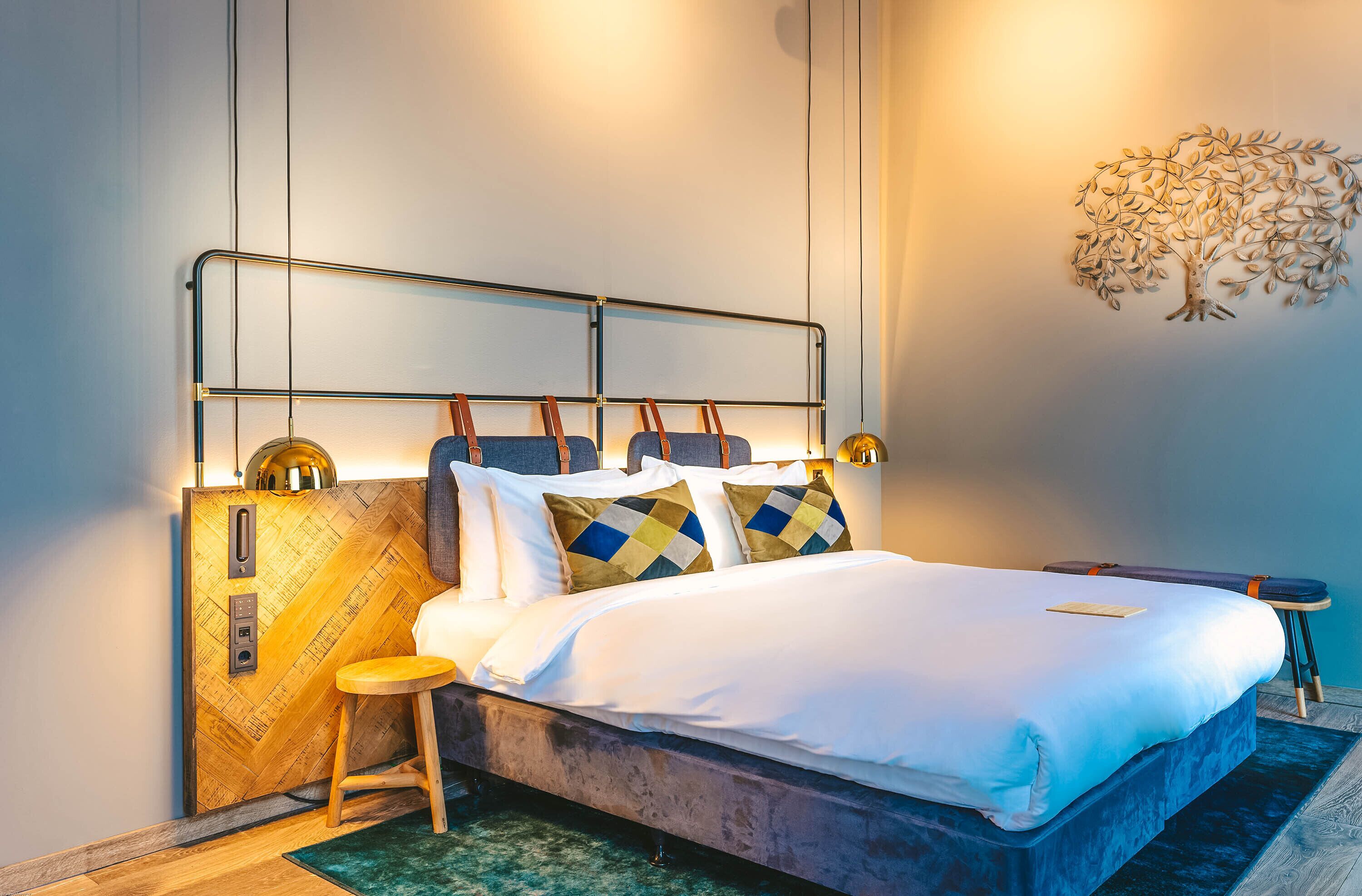 Camera da letto moderna con un letto, comodini e un elemento decorativo a parete.
