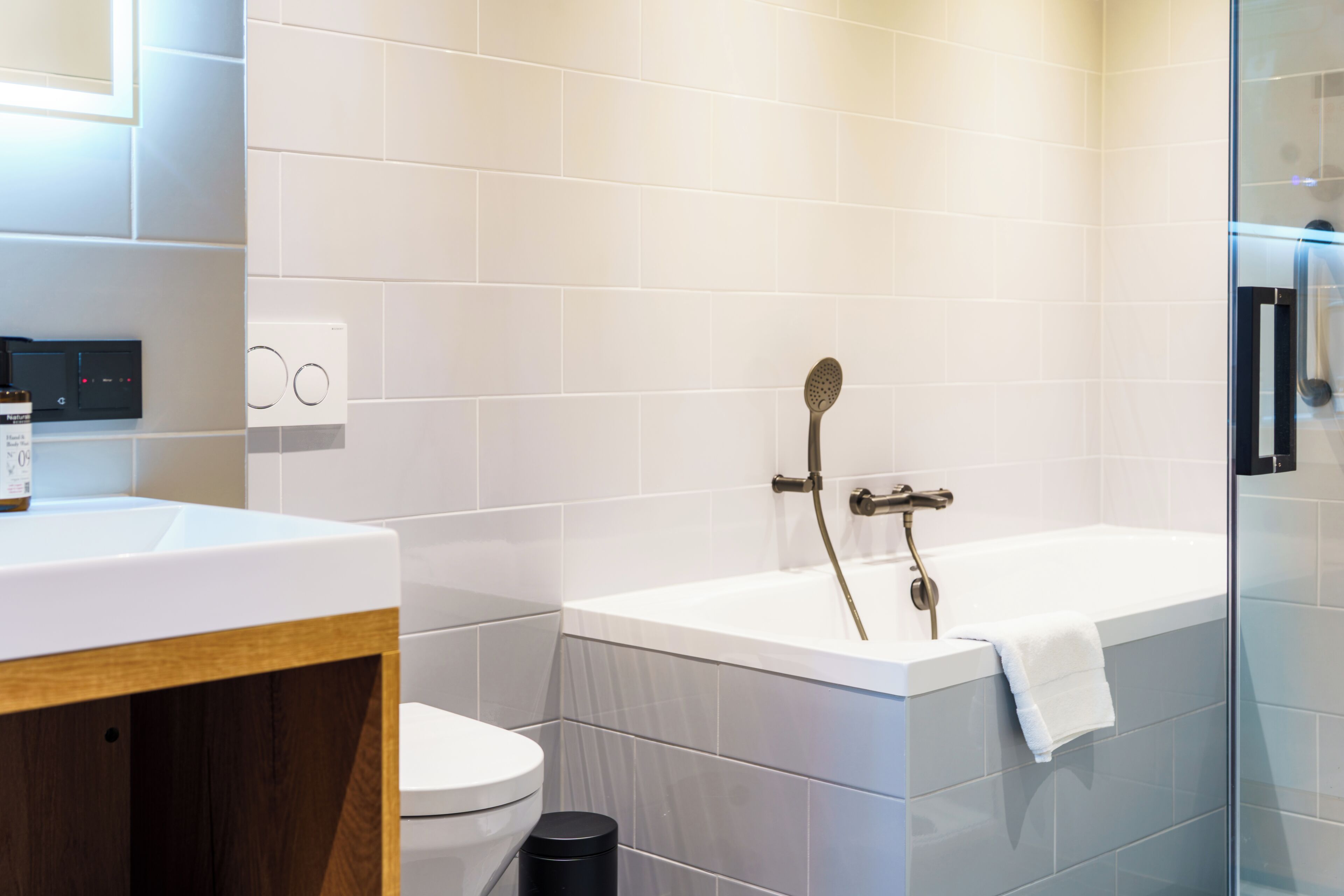 A modern bathroom with a white sink, toilet, and bathtub.