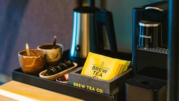 A coffee machine, a kettle, and a tray with a coffee cup and a tea bag.