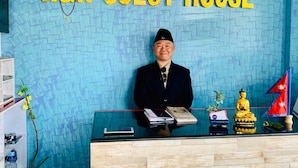 En receptionsdisk med et skilt, der viser "R&R Guest House".