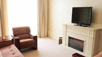 A living room with a television on a mantel, a sofa, and a fireplace.