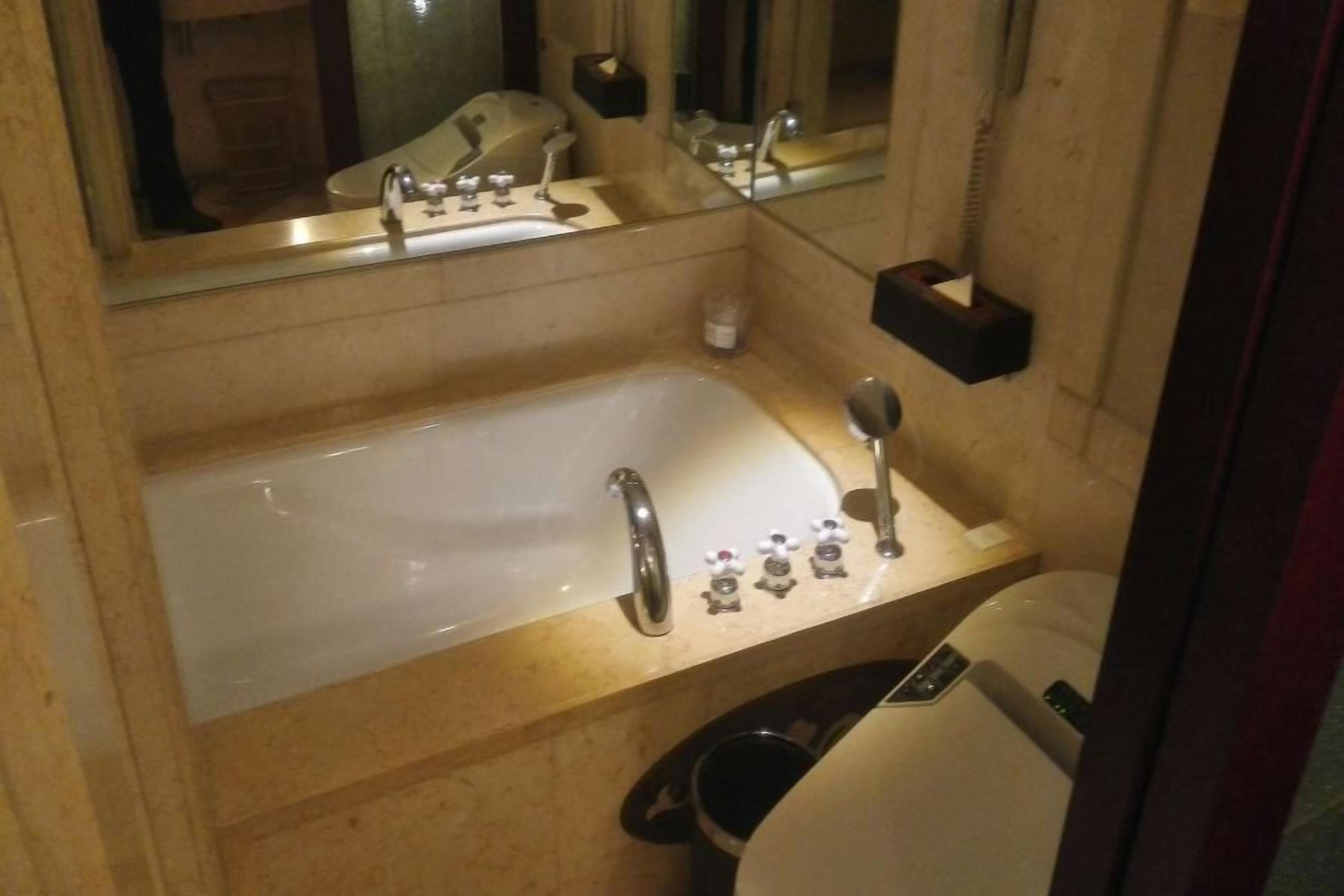 Ein Badezimmer mit Badewanne, Waschbecken, Spiegel und Toilette.