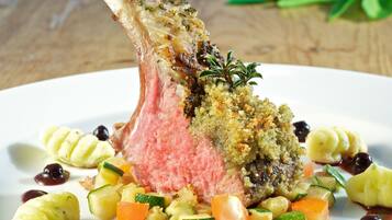 Un plato con un palillo de cordero, verduras y guarnición.