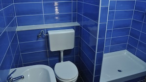 A bathroom with blue tiles, a white toilet, a white sink, and a white pedestal sink. - Naples Experience B&B (Naples)