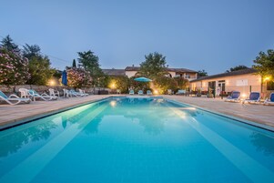 Una piscina al aire libre de temporada, sombrillas