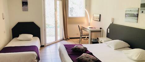 Una habitación de hotel con dos camas, un escritorio y una silla.