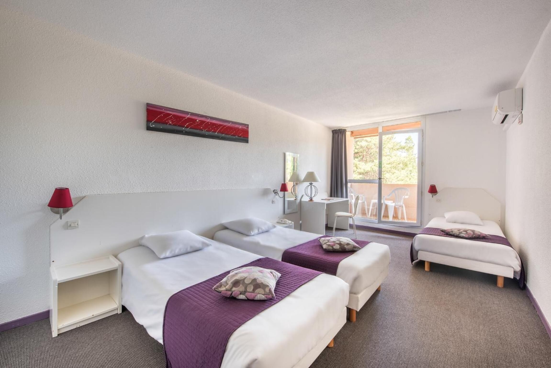 Een hotelkamer met twee éénpersoonsbedden, een bureau en een stoel.