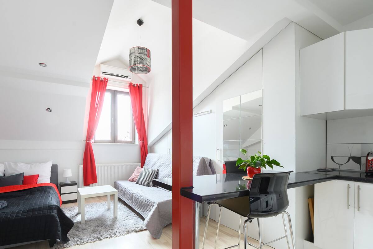 Un apartamento moderno con un dormitorio tipo loft, una kitchenette y una zona de comedor.