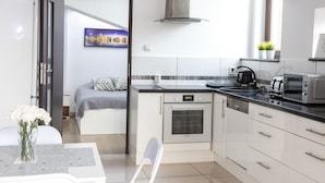 A modern kitchen with a built-in oven, a coffee maker, and a toaster. - Station Apartments Kątowa 11 Krakow (Kraków)
