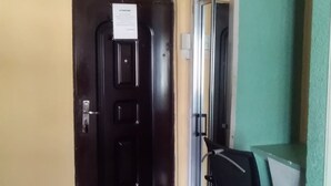 Ein Zimmer mit geschlossener Tür, einem Sessel und einem kleinen Tisch.