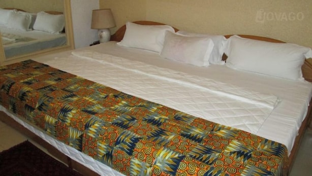 Ein Hotelzimmer mit Bett, Nachttisch und Lampe.