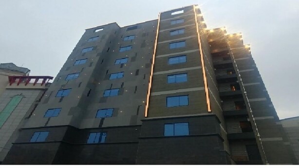 Un immeuble à plusieurs étages doté d’une architecture moderne, caractérisé par une série de balcons et de fenêtres.