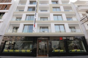 Een hotel met meerdere verdiepingen, een moderne gevel, grote ramen en een opvallende entree.