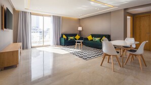 Un salon moderne comprenant un canapé, une table basse et un coin repas avec des chaises.