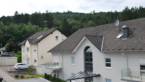 Un quartier résidentiel où les maisons sont dotées de toits à pignon, d’antennes paraboliques et d’un petit espace de stationnement.