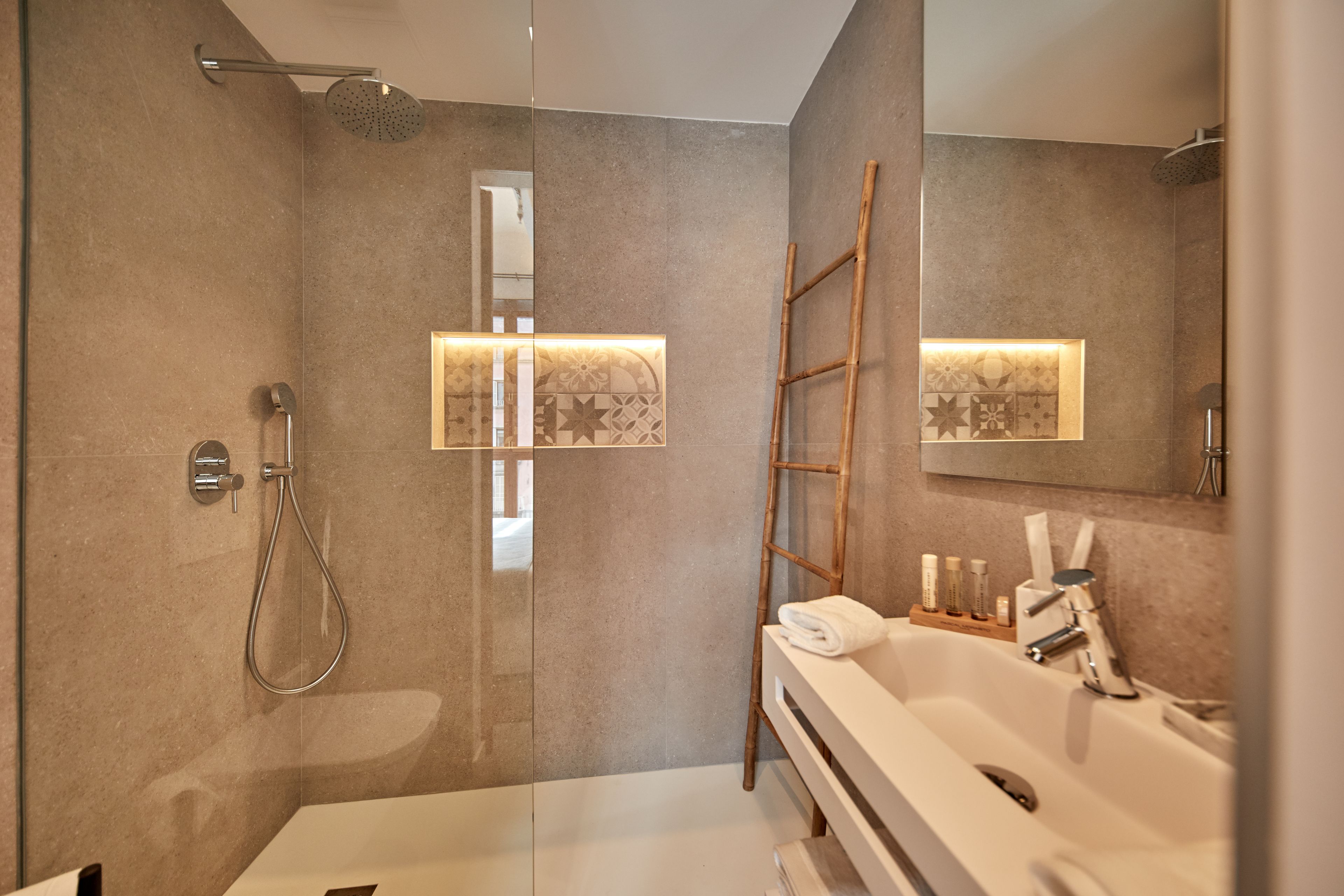 A modern bathroom with a glass-enclosed shower, a white bathtub, and a vanity with a mirror.
