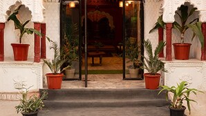 Uma entrada com arcos ornamentados e plantas em vasos.