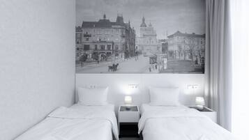 Quarto de hotel com duas camas, um mural com vista para a cidade na parede e vista para a rua.