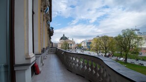 Un balcón con vistas a una plaza pública y un edificio histórico con una cúpula.