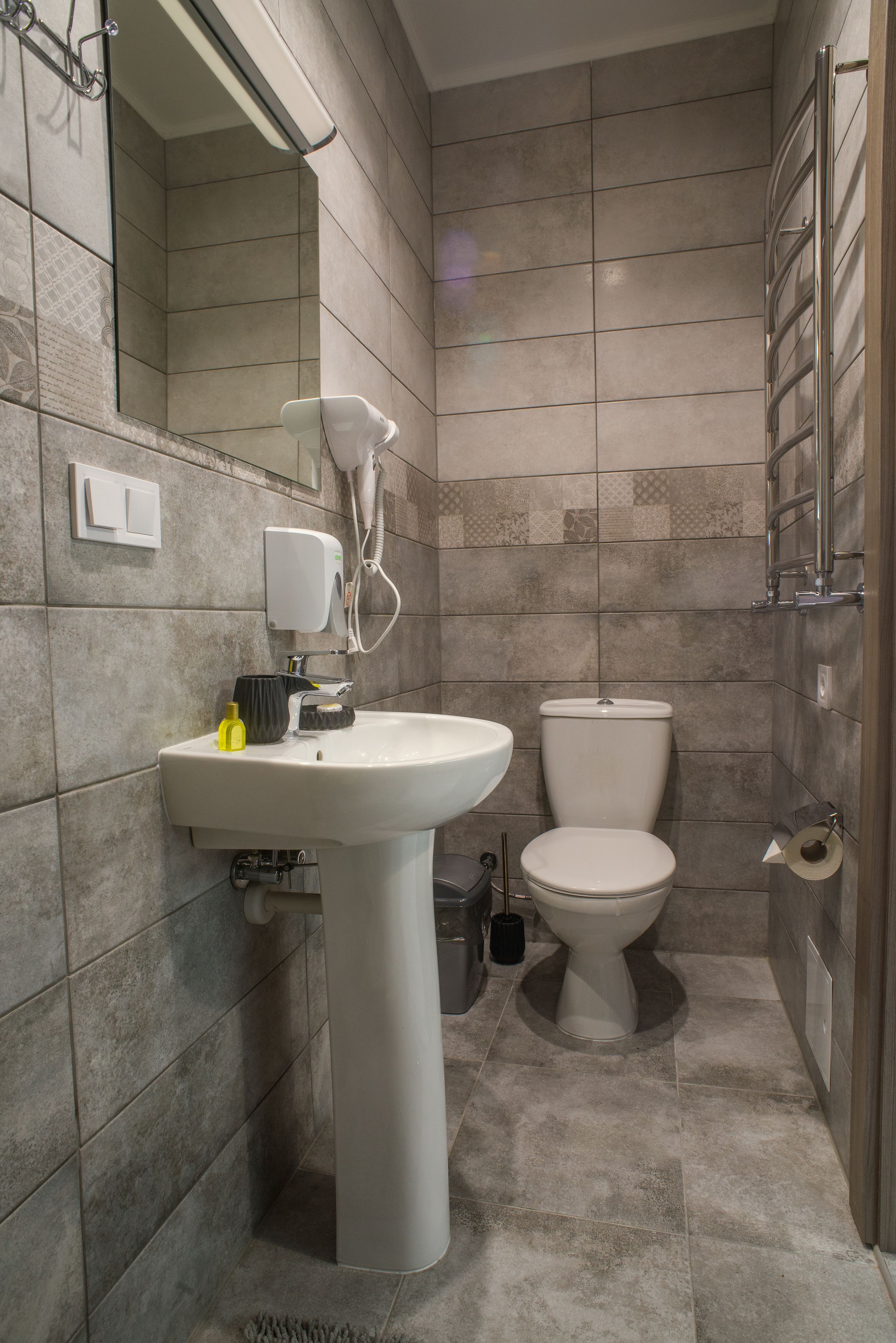 Un baño con lavamanos, inodoro y espejo.