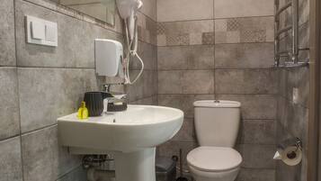 Une salle de bain avec un lavabo, des toilettes et un miroir.