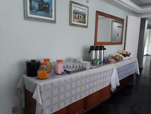 A breakfast buffet setup with various food items and beverages. - San Marino Hotel (São José dos Campos)