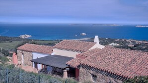 A coastal villa with terracotta tiled roofs, stone walls, and a view of the sea. - Luxury Villa's Valle dell'Erica (Santa Teresa di Gallura)