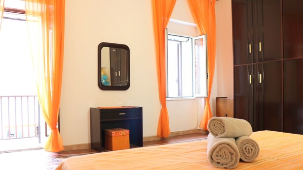 Ein Hotelzimmer mit Bett, Schreibtisch, Spiegel und Kleiderschrank.