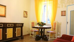 Ein Zimmer mit Esstisch, zwei Stühlen, einer Couch und einem Schrank.
