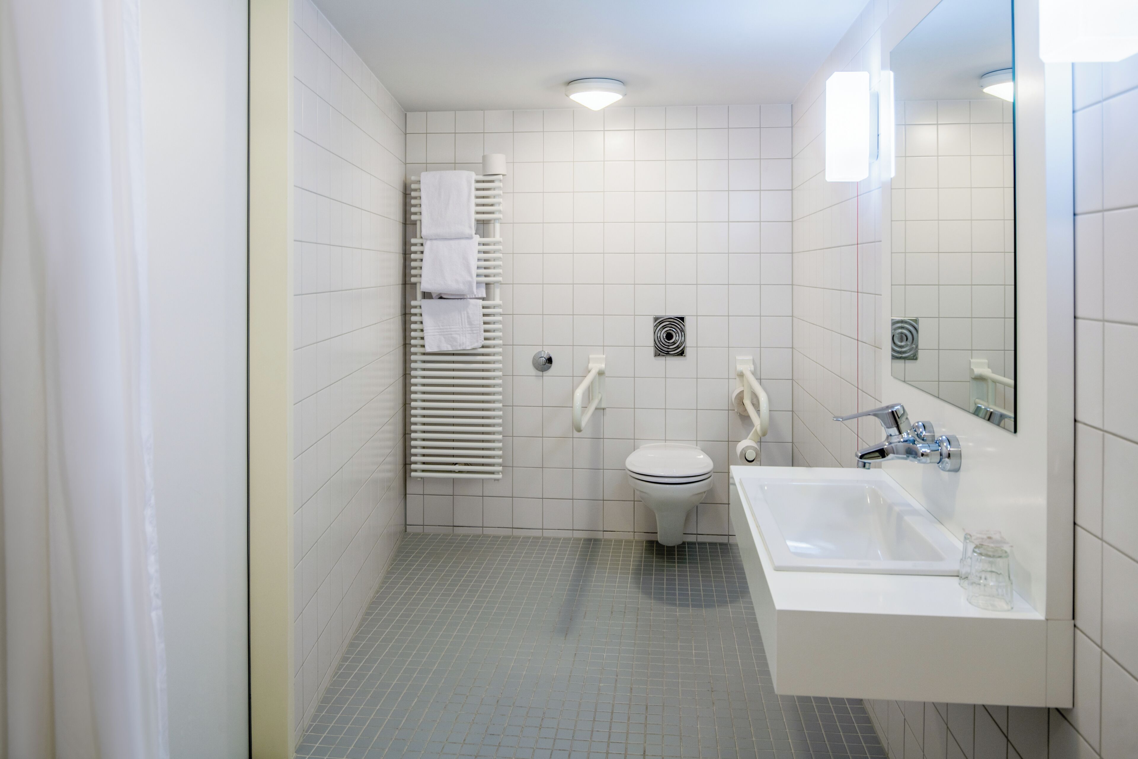 Ein modernes Badezimmer mit Toilette, Waschbecken und Handtuchhalter.